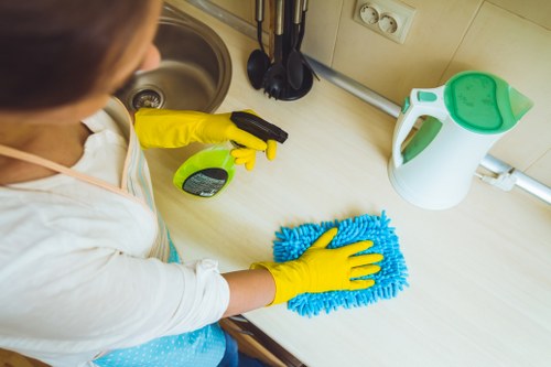 Cleaner wearing PPE while carrying out a cleaning task